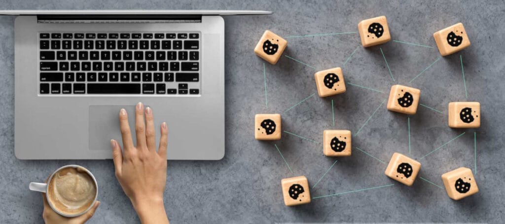 Cookies die aan elkaar gelinkt zijn, naast een laptop.